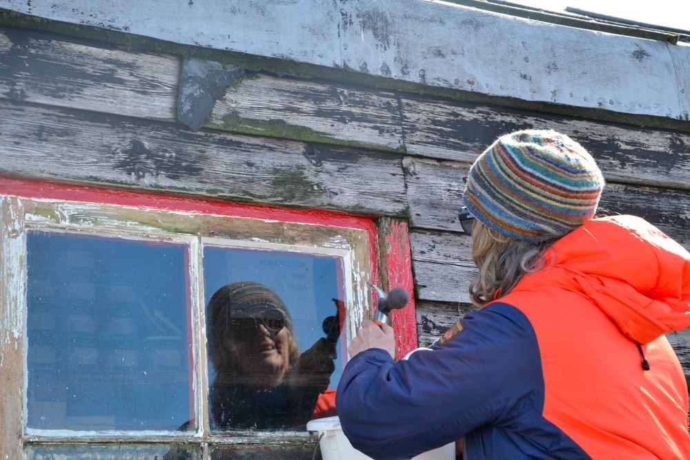 General assistant Lisa Ford repairs a window frame