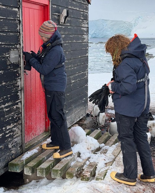 Lisa opening a red wooden door