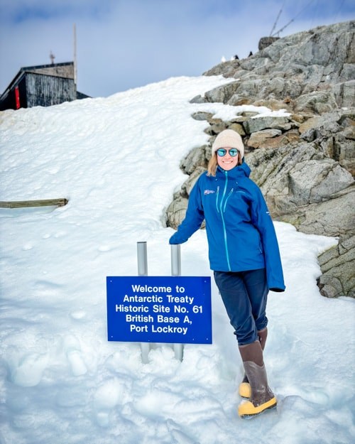 Bridie standing beside the Port Lockroy sign in her boots